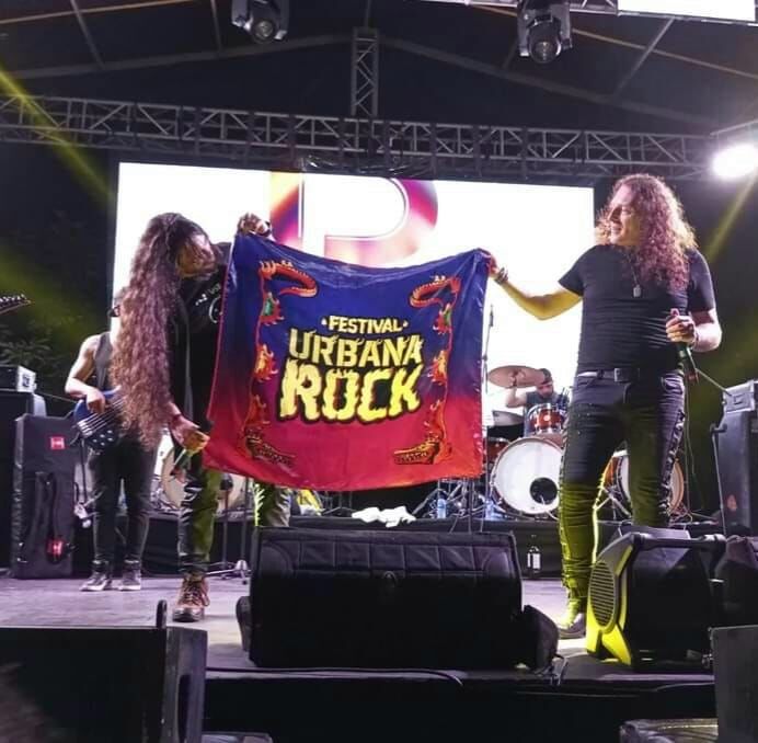 Banda mostrando la bandera del festival en tarima